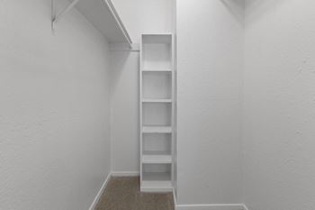The closet in a small apartment with shelves and a window